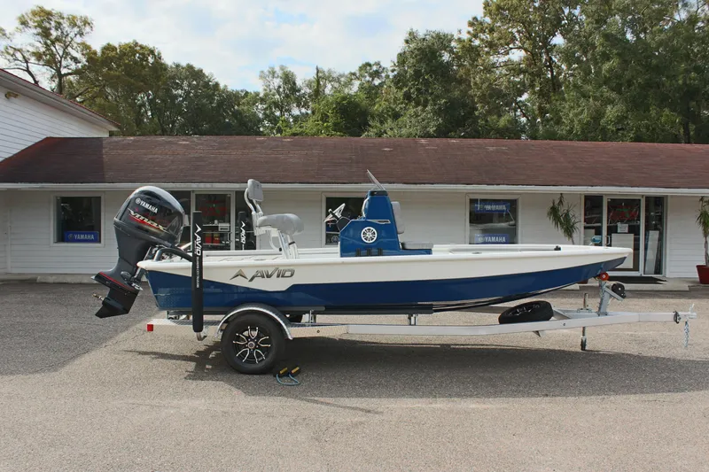 Slide: The Image of 2025 Avid 19 FSX boat on trailer, parked outside a building. - 6