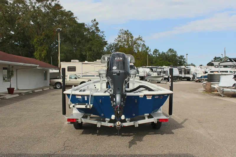 Slide: The Image of 2025 Avid 19 FSX boat on trailer, parked in a lot with RVs and trees. - 8