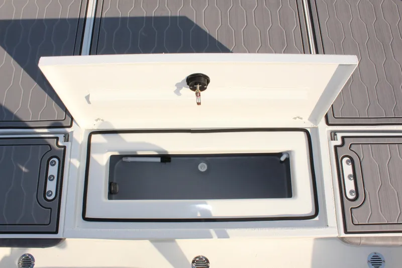 Slide: The Image of 2025 Avid 23 FSX boat storage compartment with open lid, showcasing interior design. - 14