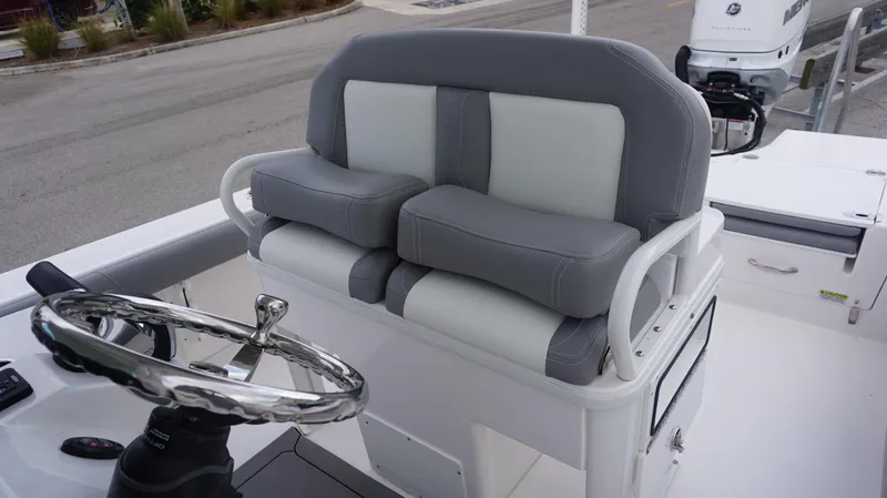 Slide: The Image of 2023 Everglades 253 CC boat helm with cushioned seating and steering wheel. - 11