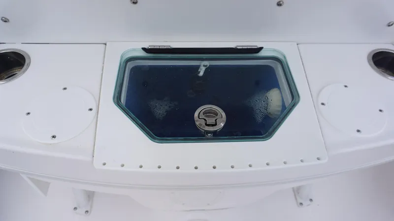 Slide: The Image of Livewell on 2023 Everglades 253 CC boat, featuring a glass lid and cup holders. - 14