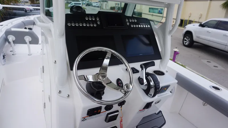 Slide: The Image of 2023 Everglades 253 CC boat dashboard with steering wheel and controls. - 16