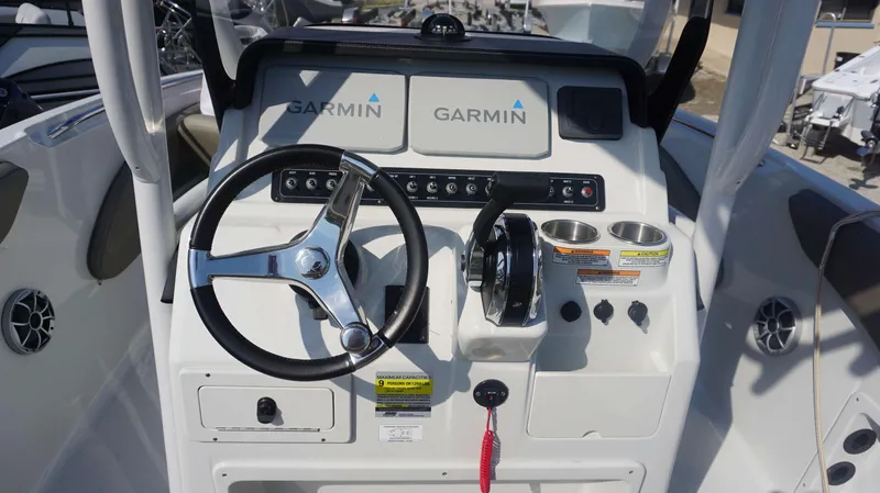 Slide: The Image of 2023 Finseeker 210 FC boat dashboard with Garmin navigation system and steering wheel. - 12