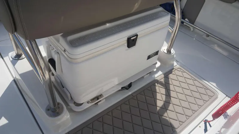 Slide: The Image of 2023 Finseeker 210 FC boat interior with cooler and cushioned seating. - 20