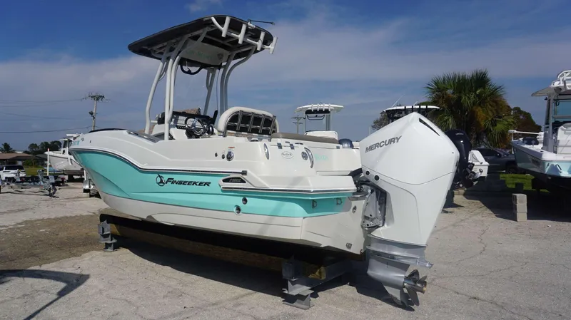 Slide: The Image of 2023 Finseeker 210 FC boat with Mercury engine, parked outdoors. - 3