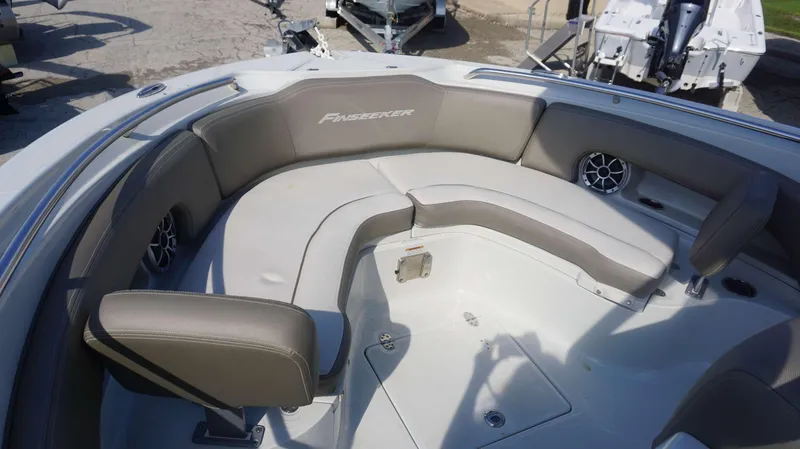 Slide: The Image of 2023 Finseeker 210 FC boat interior with cushioned seating and speakers. - 6