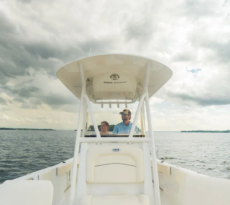 Slide: The Image of 2025 Sea Hunt Ultra 229 boat on open water under cloudy skies. - 11