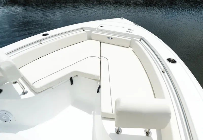 Slide: The Image of 2025 Sea Hunt Ultra 229 boat with white cushioned seating on calm water. - 12