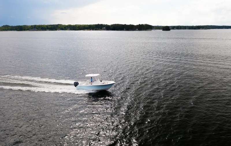 Slide: The Image of 2025 Sea Hunt Ultra 229 boat cruising on a serene lake. - 15