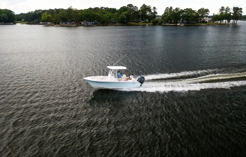 Slide: The Image of 2025 Sea Hunt Ultra 229 boat cruising on a serene lake. - 16