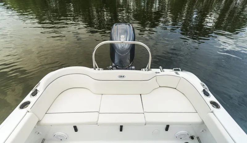 Slide: The Image of 2025 Sea Hunt Ultra 229 boat interior with outboard motor on calm water. - 22