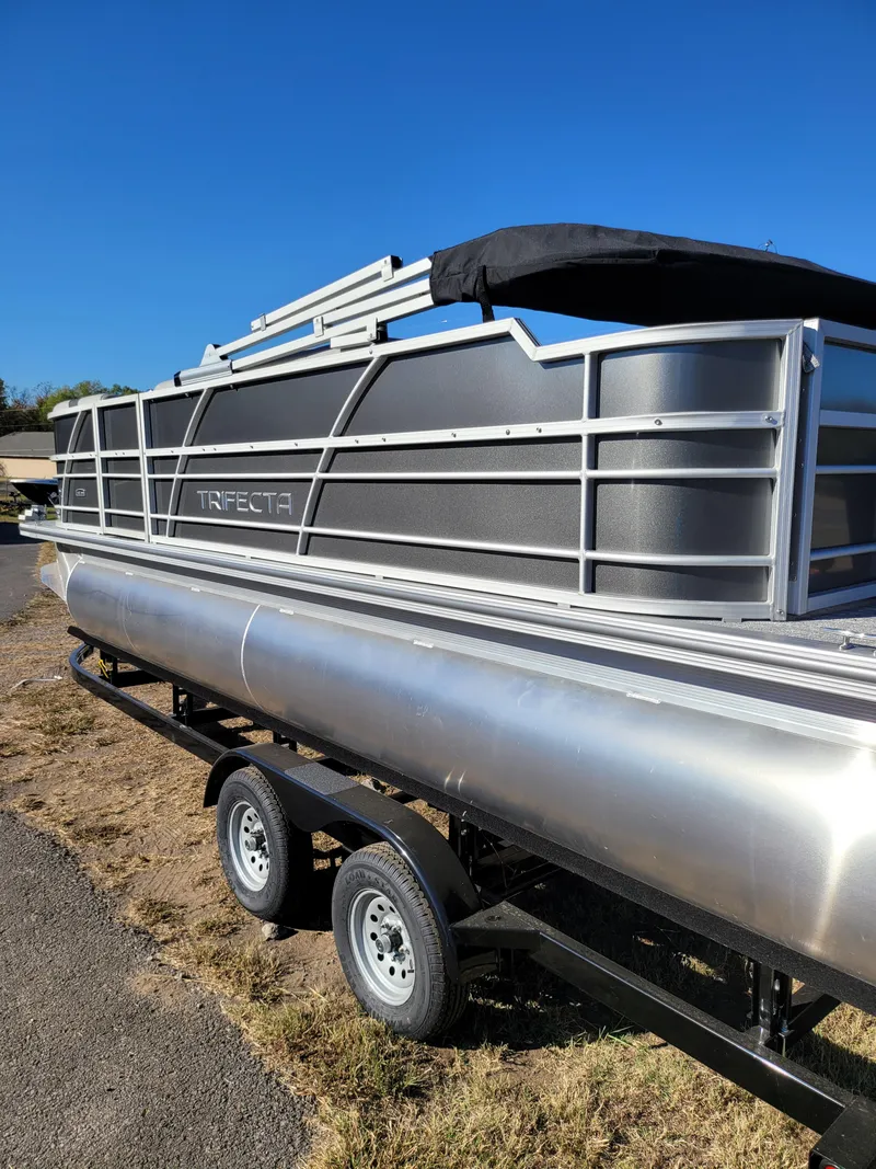 Slide: The Image of 2025 Trifecta 22TRFCLE pontoon boat on trailer, parked on grass. - 3