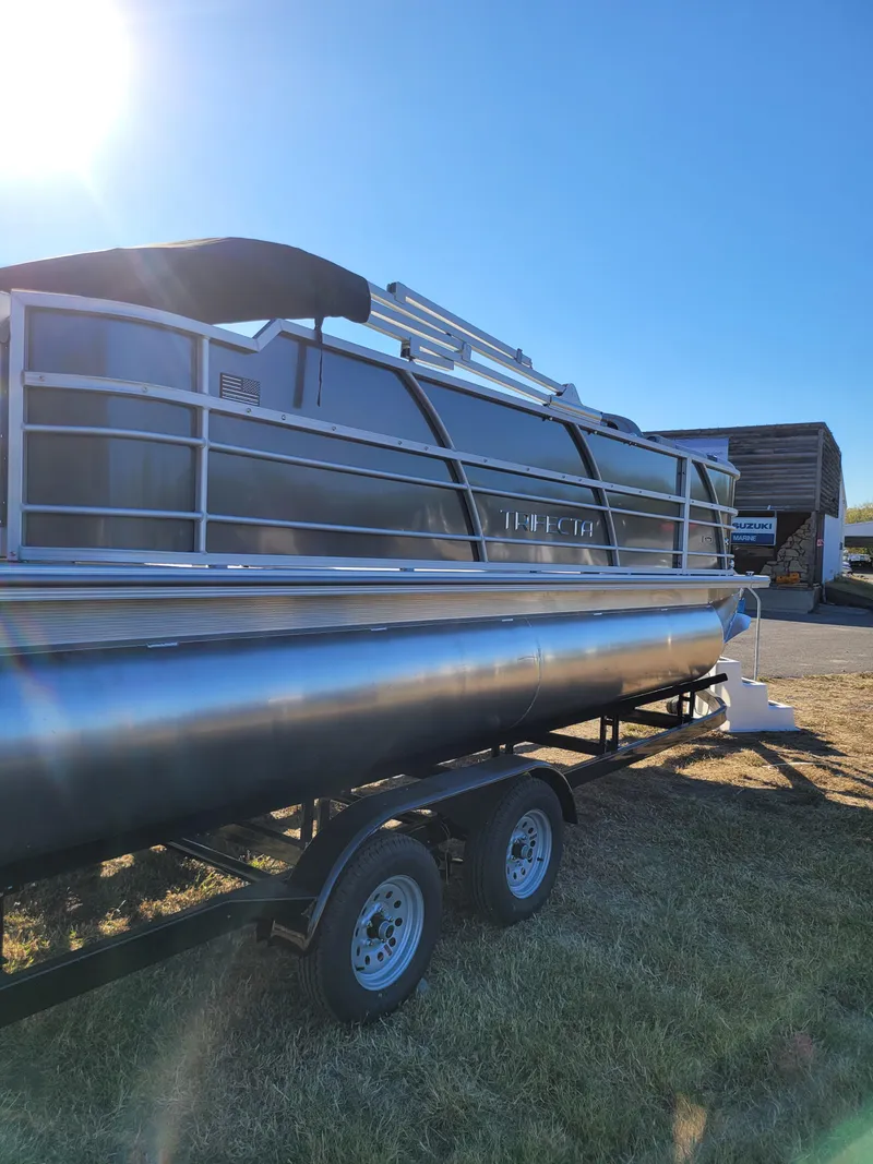 Slide: The Image of 2025 Trifecta 22TRFCLE pontoon boat on trailer under clear blue sky. - 4