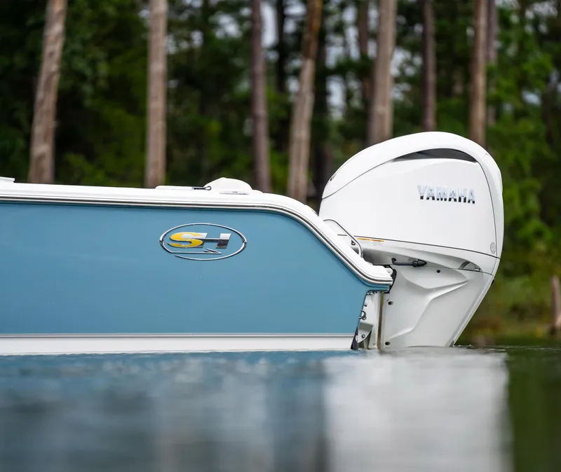 Slide: The Image of 2025 Sea Hunt Ultra 245 SE boat with Yamaha engine on calm water. - 11