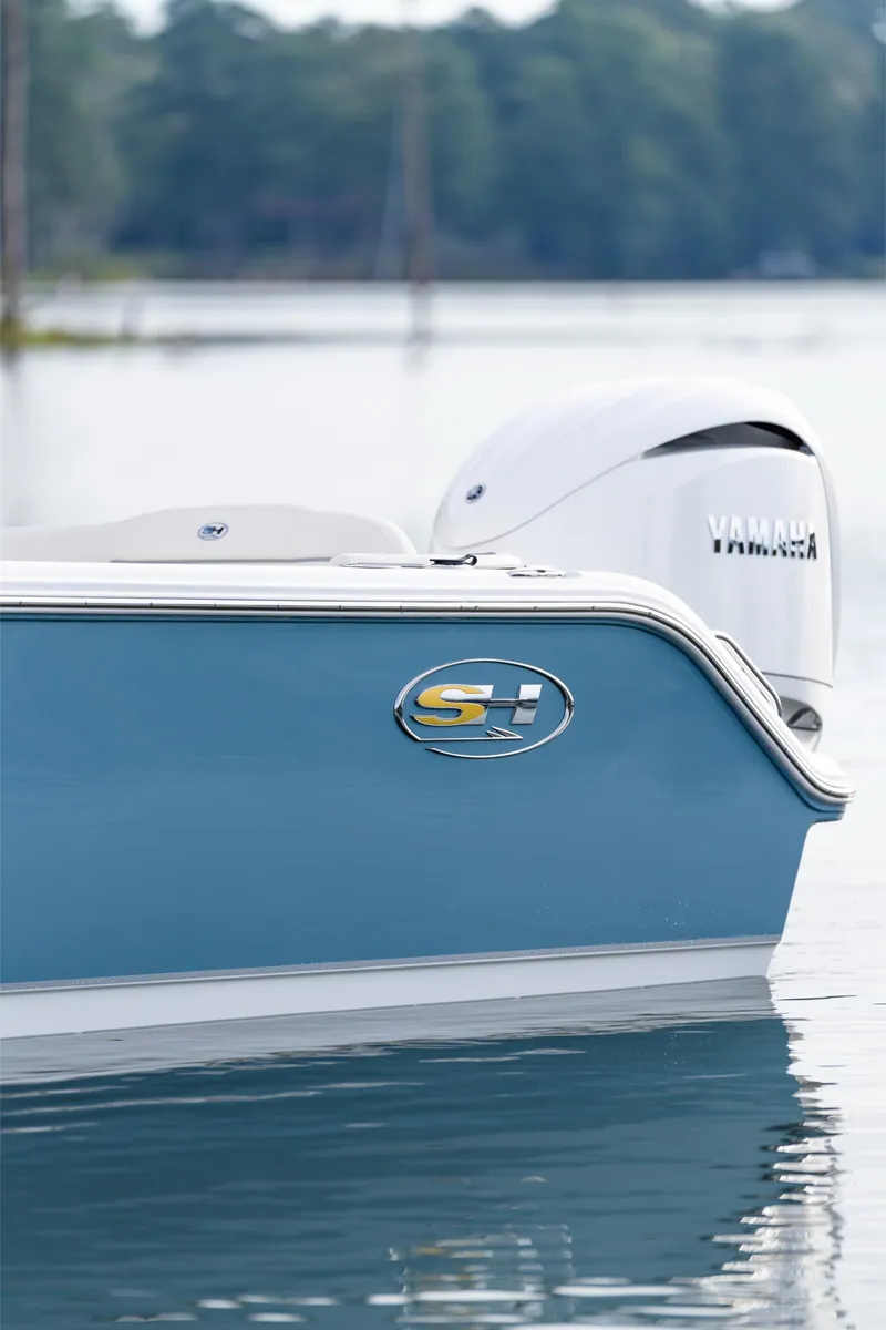 Slide: The Image of 2025 Sea Hunt Ultra 245 SE boat on calm water, featuring Yamaha engine. - 15
