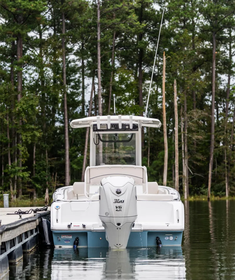 Slide: The Image of 2025 Sea Hunt Ultra 245 SE boat docked in a serene forest setting. - 16