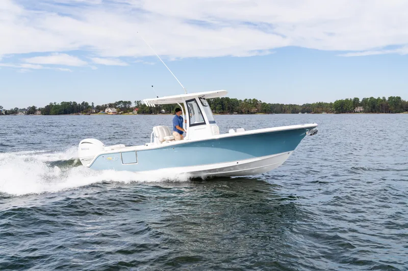 Slide: The Image of 2025 Sea Hunt Ultra 245 SE boat cruising on a lake under a clear sky. - 5