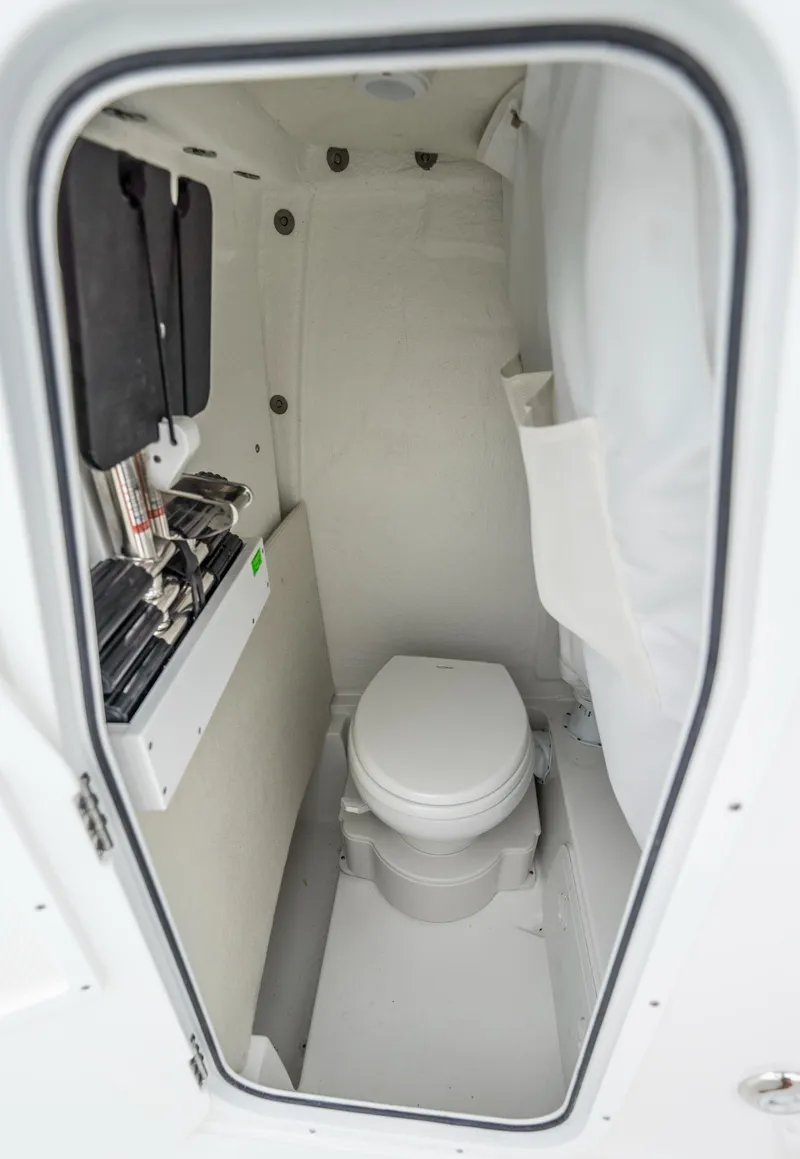 Slide: The Image of 2025 Sea Hunt Ultra 245 SE boat interior with compact marine toilet. - 9