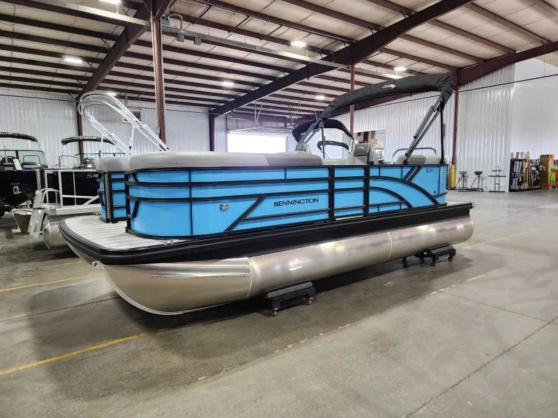 Slide: The Image of 2025 Bennington 20SSR pontoon boat in a warehouse setting. - 0