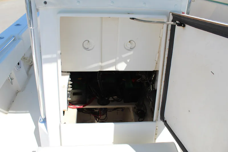 Slide: The Image of Open storage compartment on 2002 Contender 31 CC boat, showing internal wiring and components. - 21