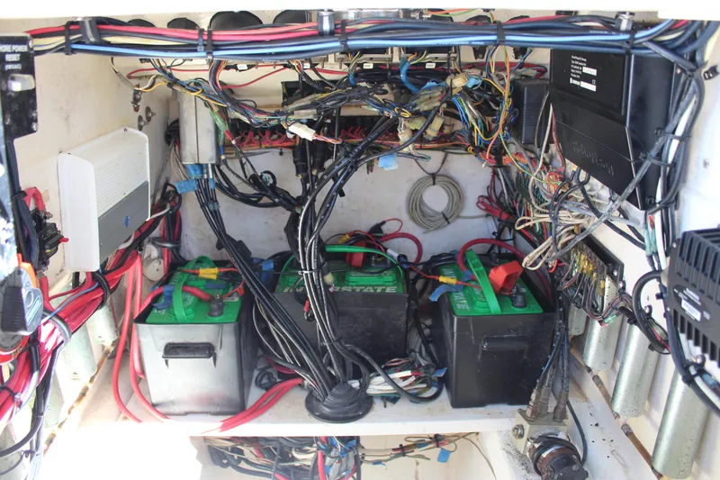 Slide: The Image of 2002 Contender 31 CC boat battery compartment with wiring and three batteries. - 22
