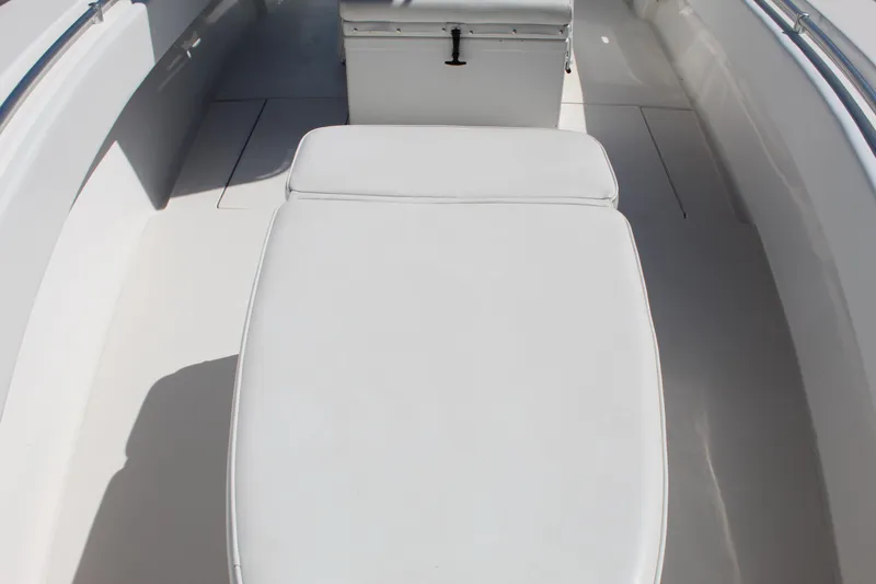 Slide: The Image of 2002 Contender 31 CC boat interior with white cushioned seating and storage. - 25