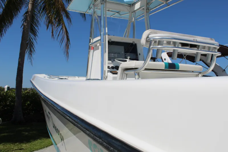 Slide: The Image of 2002 Contender 31 CC boat with sleek design, palm tree backdrop, and clear blue sky. - 18