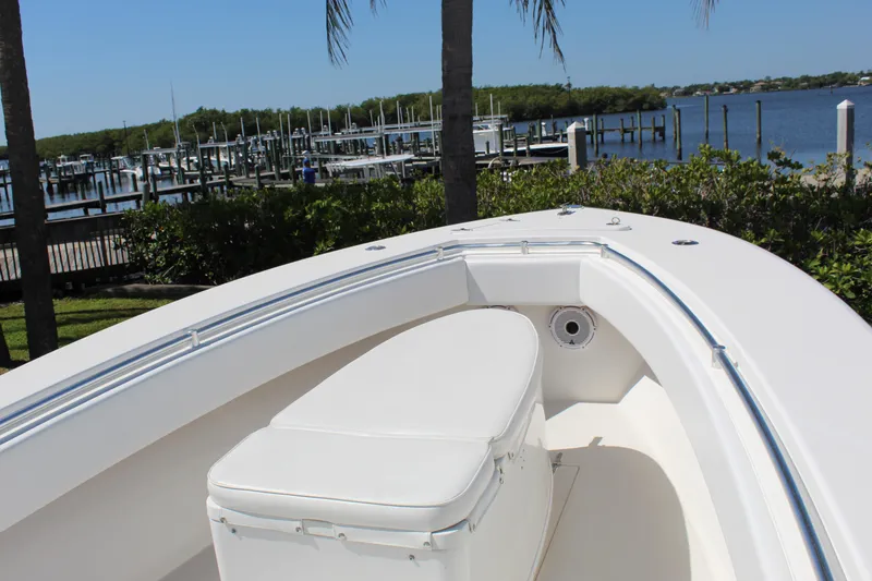 Slide: The Image of 2002 Contender 31 CC boat with white seating, docked near a marina. - 1