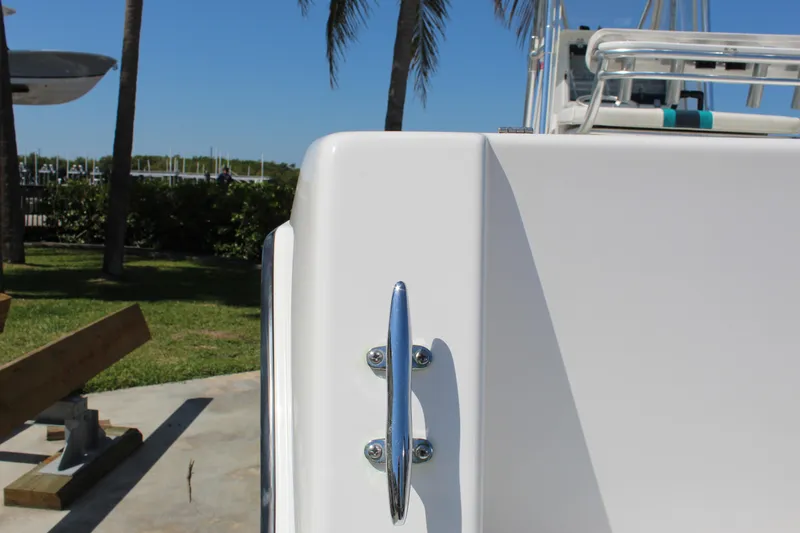 Slide: The Image of 2002 Contender 31 CC boat detail with chrome handle, palm trees, and marina background. - 15