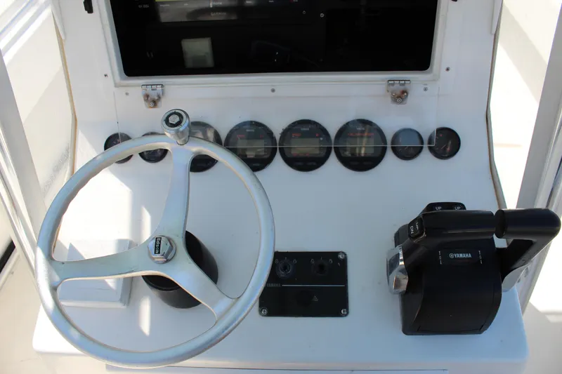 Slide: The Image of 2002 Contender 31 CC boat dashboard with steering wheel and Yamaha controls. - 43