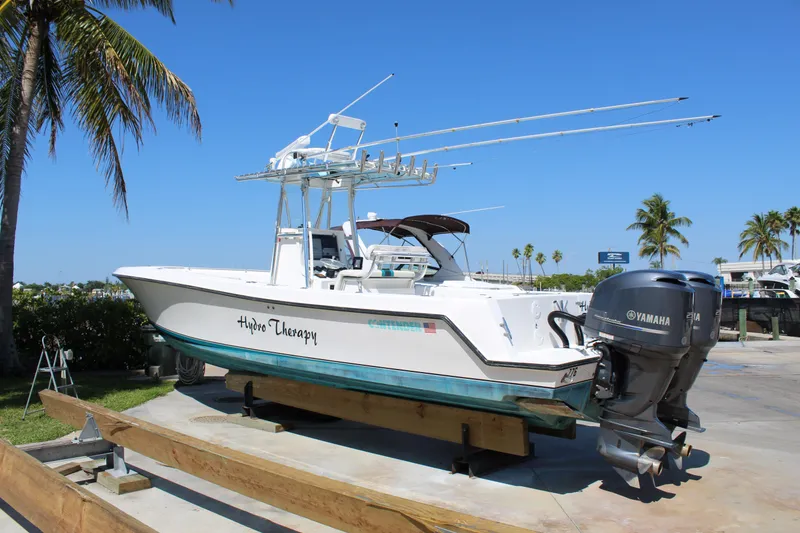 Slide: The Image of 2002 Contender 31 CC boat with Yamaha engines, docked under clear blue sky. - 11