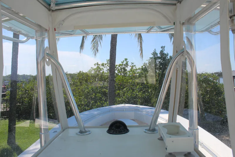 Slide: The Image of 2002 Contender 31 CC boat interior with clear canopy and lush greenery view. - 14