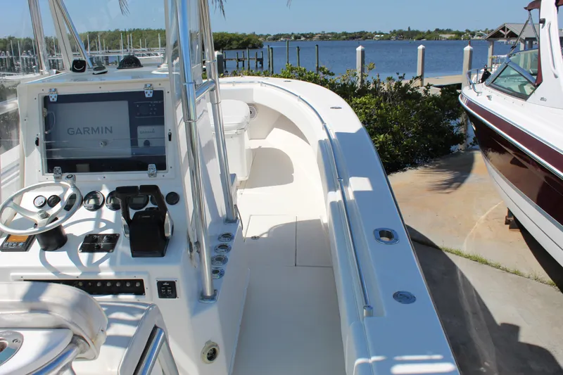 Slide: The Image of 2002 Contender 31 CC boat with Garmin navigation, docked by a scenic waterfront. - 4