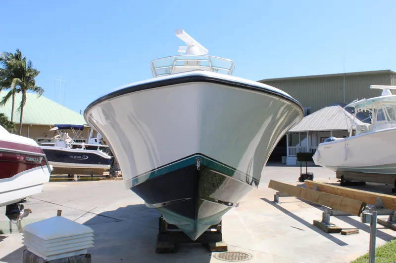 Slide: The Image of 2002 Contender 31 CC boat on display at a marina, front view. - 36