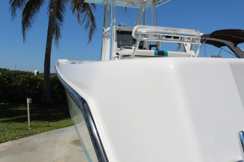 Slide: The Image of 2002 Contender 31 CC boat, sleek white design, docked under clear blue sky. - 6