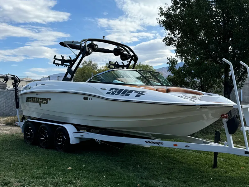 Slide: The Image of 2025 Sanger 231SL boat on trailer, parked on grass under cloudy sky. - 1