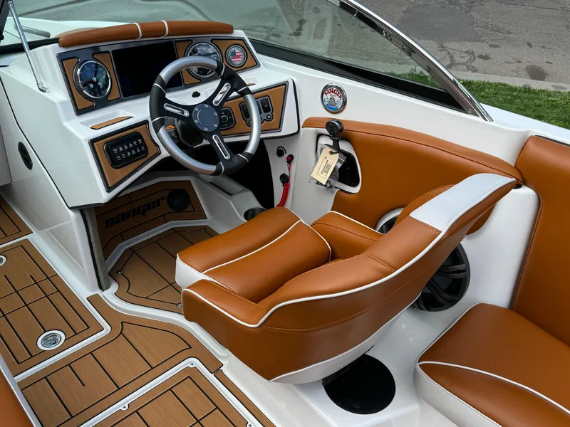 Slide: The Image of 2025 Sanger 231SL boat interior with brown leather seats and modern dashboard. - 11