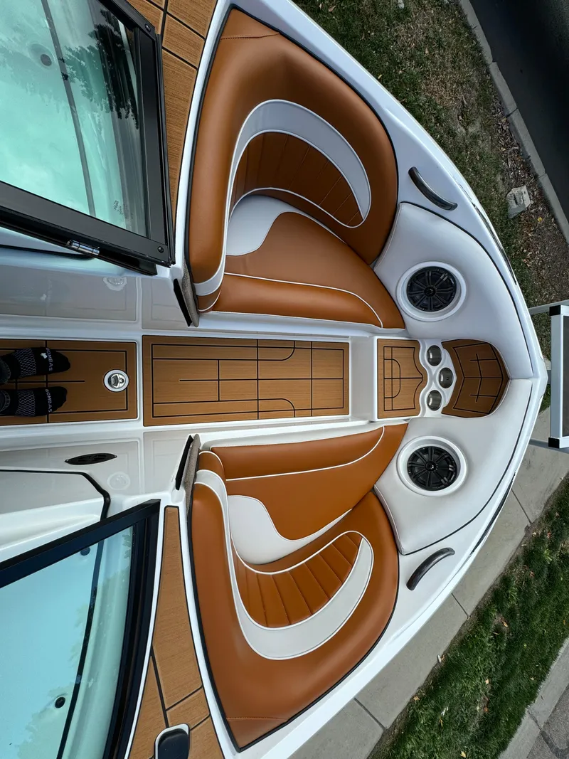 Slide: The Image of 2025 Sanger 231SL boat interior with brown and white seating, sleek design. - 13