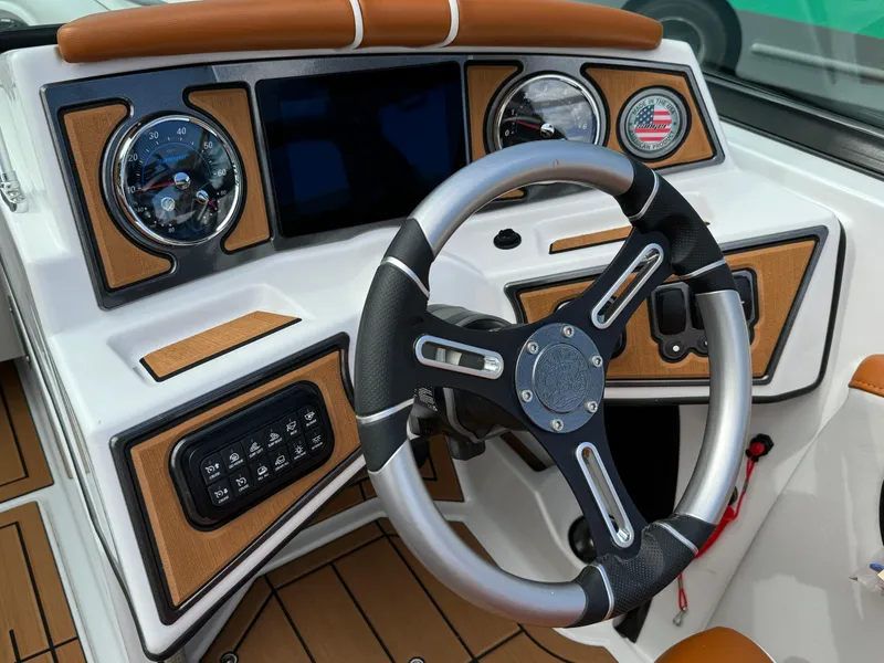 Slide: The Image of 2025 Sanger 231SL boat dashboard with modern steering wheel and control panel. - 21