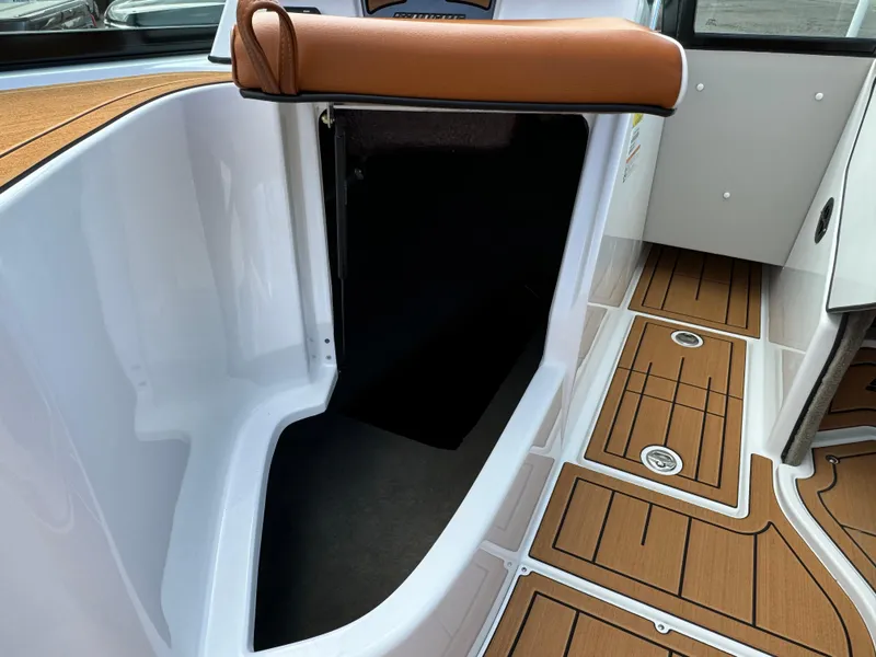 Slide: The Image of 2025 Sanger 231SL boat interior with teak flooring and white seating. - 23