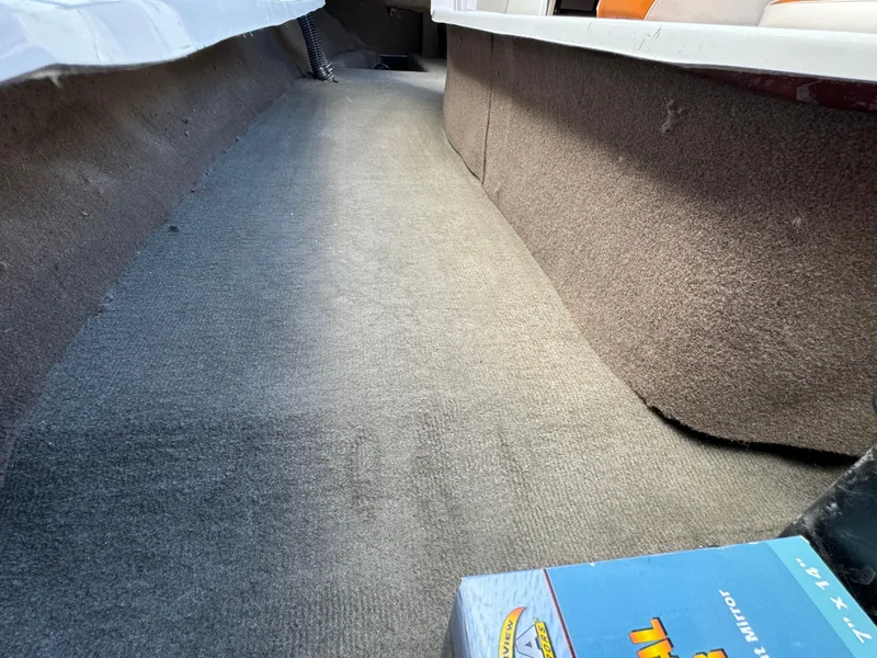 Slide: The Image of Interior of 2025 Sanger 231SL boat with carpeted flooring and storage space. - 24