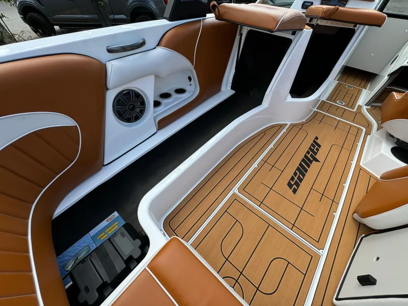 Slide: The Image of 2025 Sanger 231SL boat interior with brown and white seating, teak-style flooring. - 25