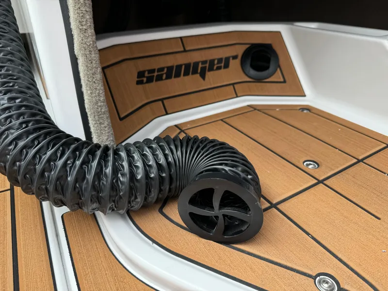 Slide: The Image of 2025 Sanger 231SL boat interior with black hose on teak flooring. - 33