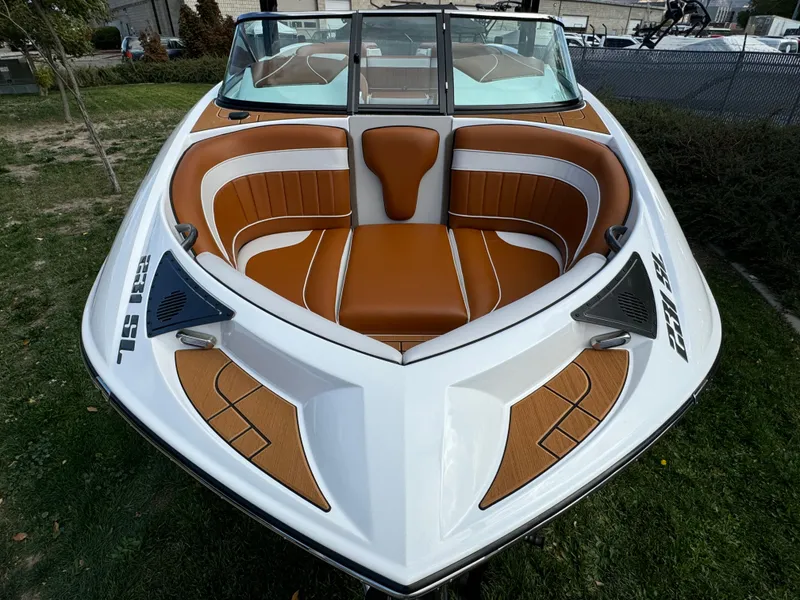 Slide: The Image of 2025 Sanger 231SL boat with brown and white interior, parked on grass. - 7