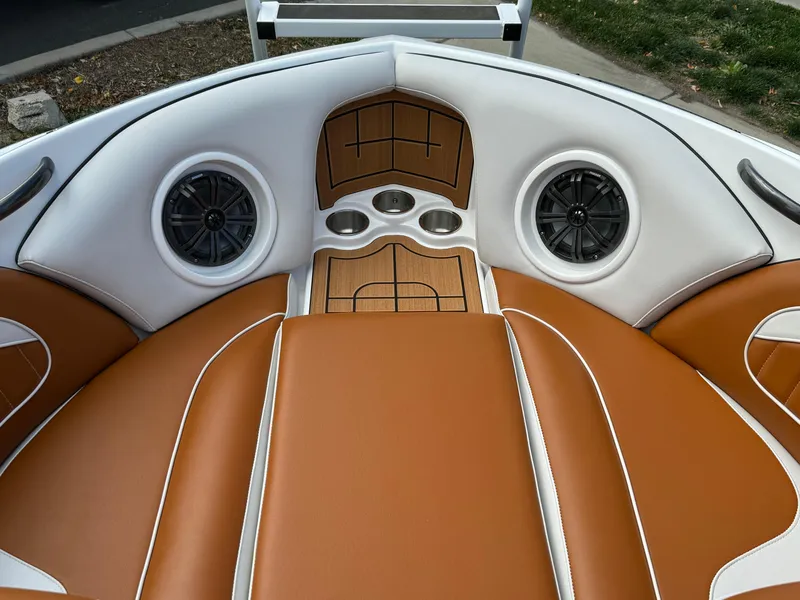 Slide: The Image of 2025 Sanger 231SL boat interior with tan leather seats and built-in speakers. - 8