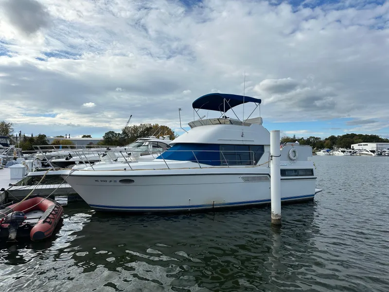 The Image of 1994 Carver 350 Aft Cabin Motor Yacht docked on a calm waterway. - 0
