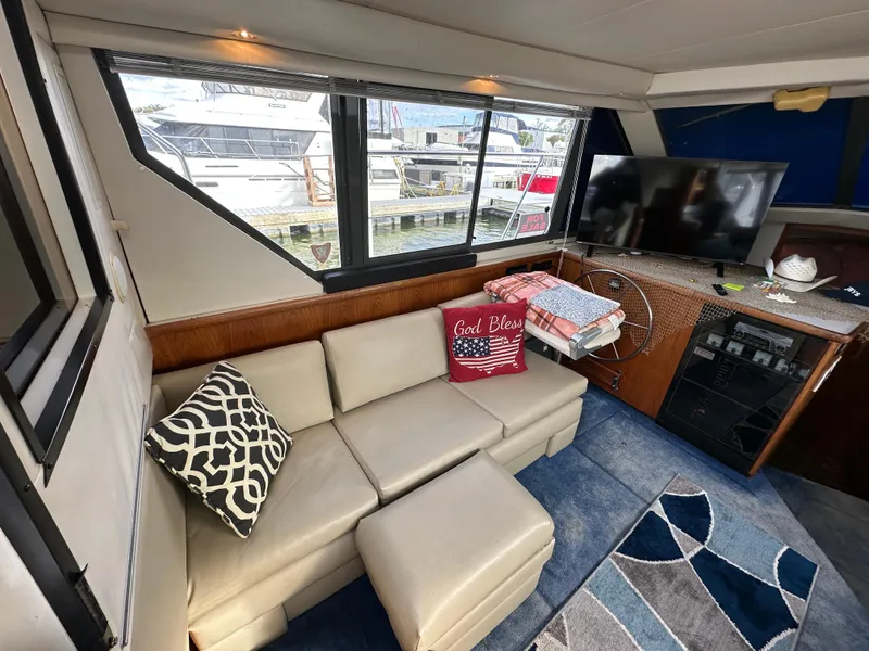 Slide: The Image of 1994 Carver 350 Aft Cabin Motor Yacht interior with sofa, TV, and nautical decor. - 12