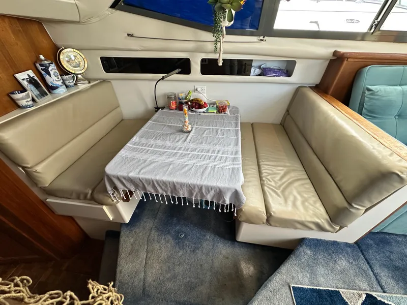 Slide: The Image of 1994 Carver 350 Aft Cabin Motor Yacht interior with dining area and table setting. - 14