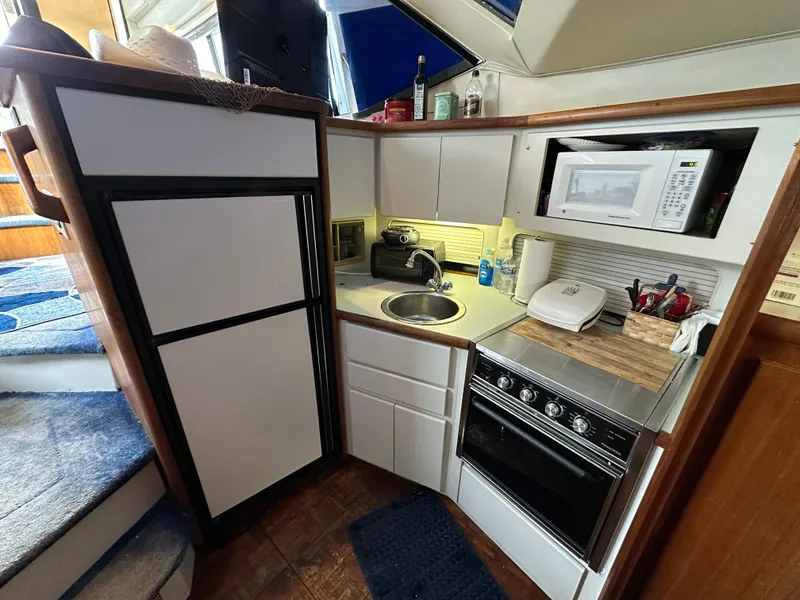 Slide: The Image of Compact kitchen in a 1994 Carver 350 Aft Cabin Motor Yacht with appliances and storage. - 16