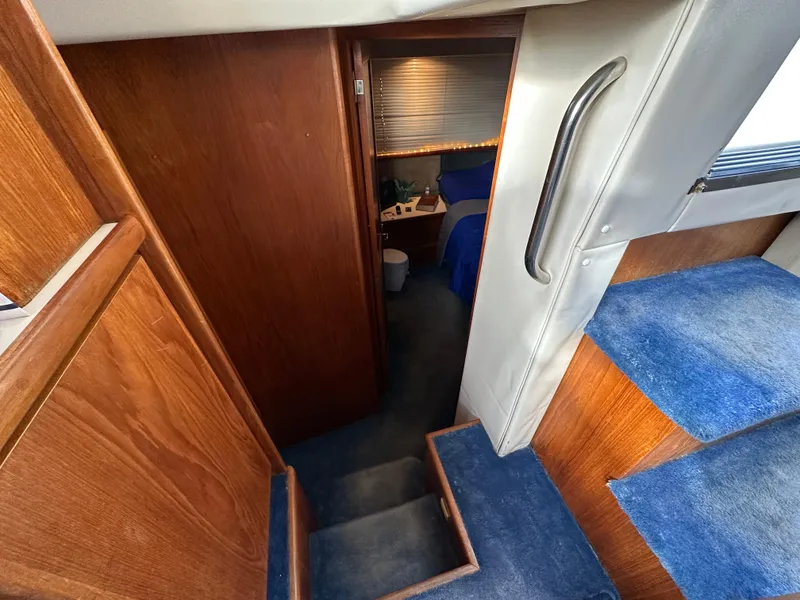 Slide: The Image of 1994 Carver 350 Aft Cabin Motor Yacht interior with wooden stairs and blue carpet. - 19
